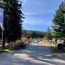 Naturpark Zentrum Einfahrt, © Naturpark Hohe Wand Einfahrt zum Naturpark Zentrum mit Fahnen und Bäumen.