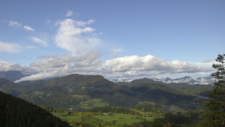 Aussicht, © vom Waldeggehaus, Foto Apfler Susi Panoramablick auf eine grüne Berglandschaft unter blauem Himmel mit Wolken.