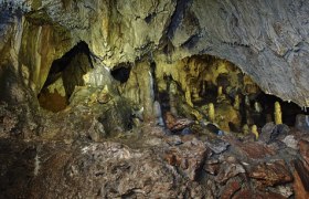 Interior view of a cave with stalagmites and stalactites.