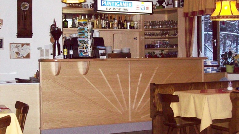 Interior view of an inn with bar and tables.
