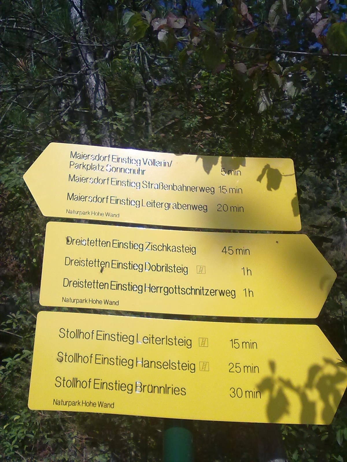 Sárga jelzőtáblák a Hohe Wand natúrparkban a különböző túraútvonalakkal és a gyaloglási időkkel.