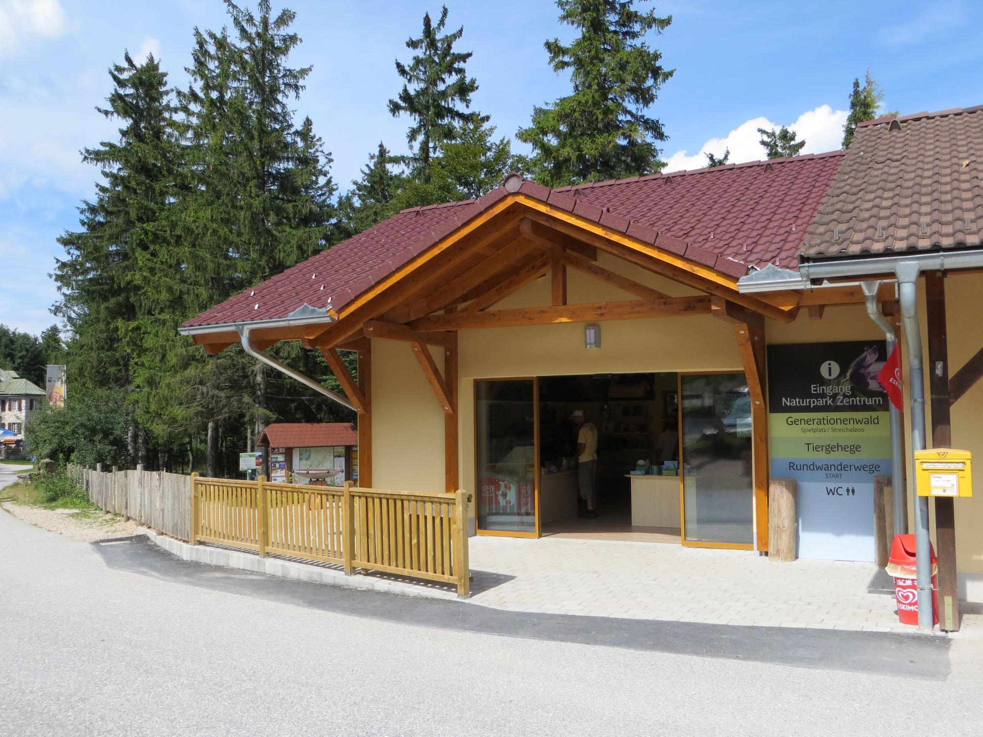 Entrance to a nature park center with wooden veranda and information sign.