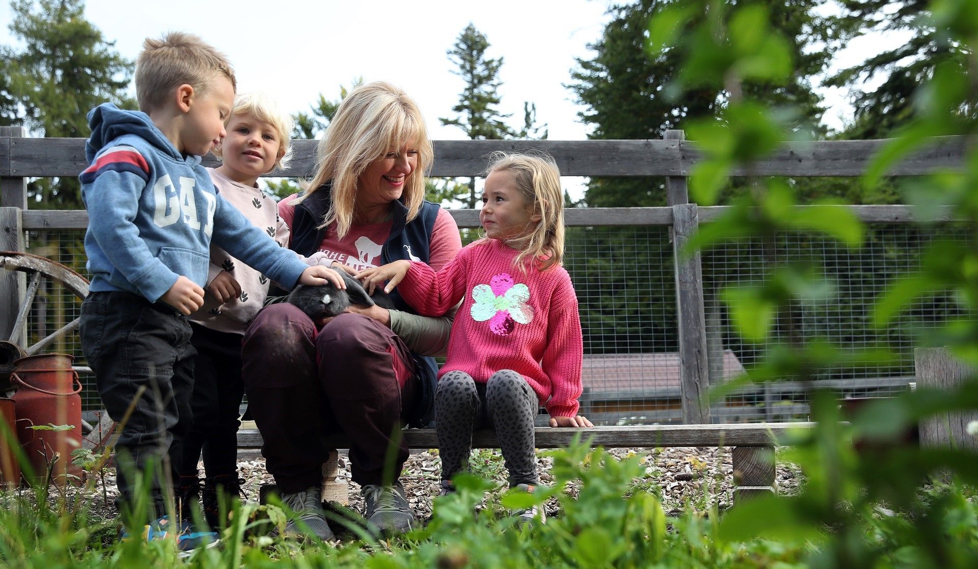 3 Kinder und eine Mitarbeiterin mit einem Kaninchen