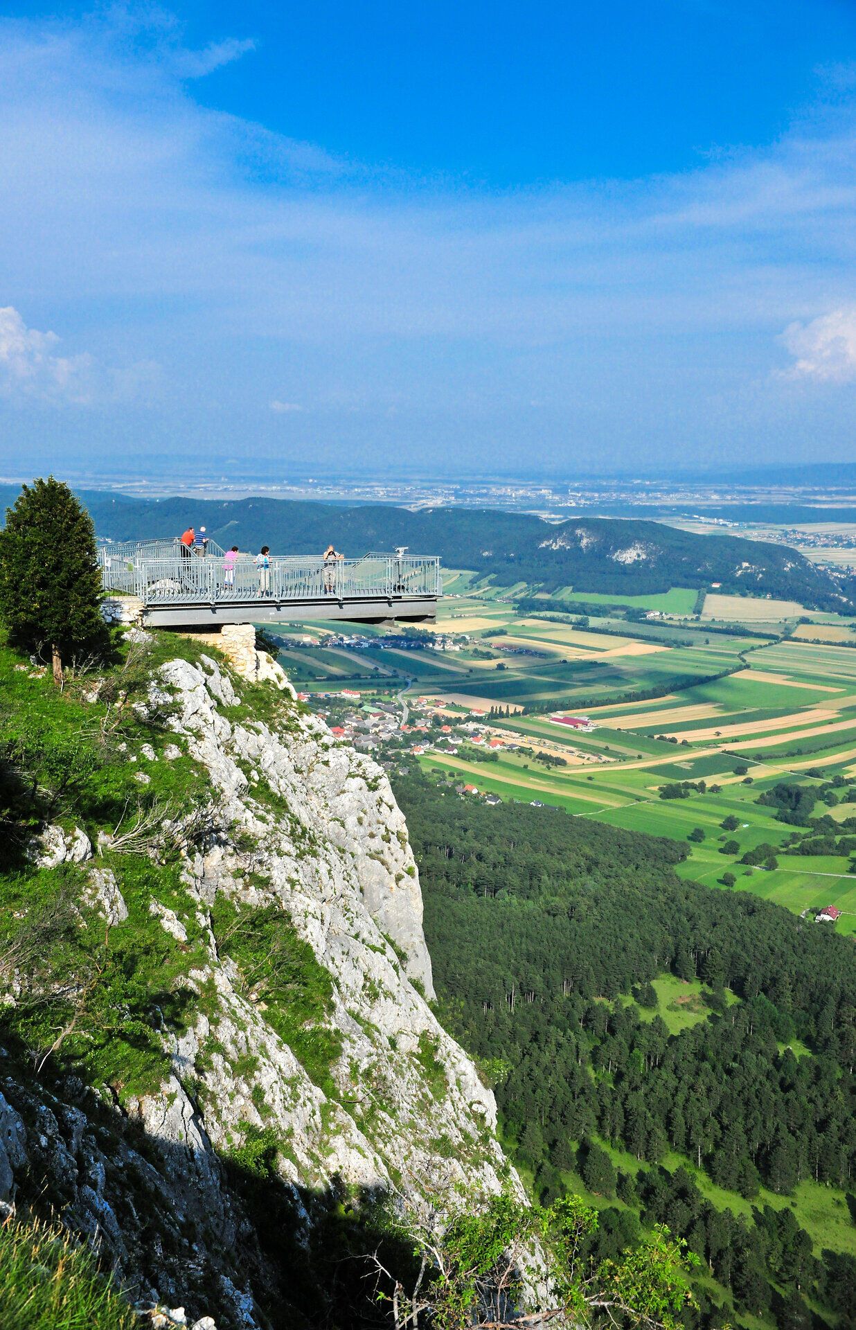 Der Skywalk bietet atemberaubende Ausblicke auf die sanften Hügel und weiten Felder der Umgebung. Hier, hoch oben auf dem Felsen, spürt man die frische Bergluft und die Freiheit der Natur. Ein unvergessliches Erlebnis für alle, die die Schönheit der Alpen genießen möchten.