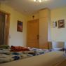 Komfortables Hotelzimmer mit Holzmöbeln, Bett, TV und Sitzbereich.