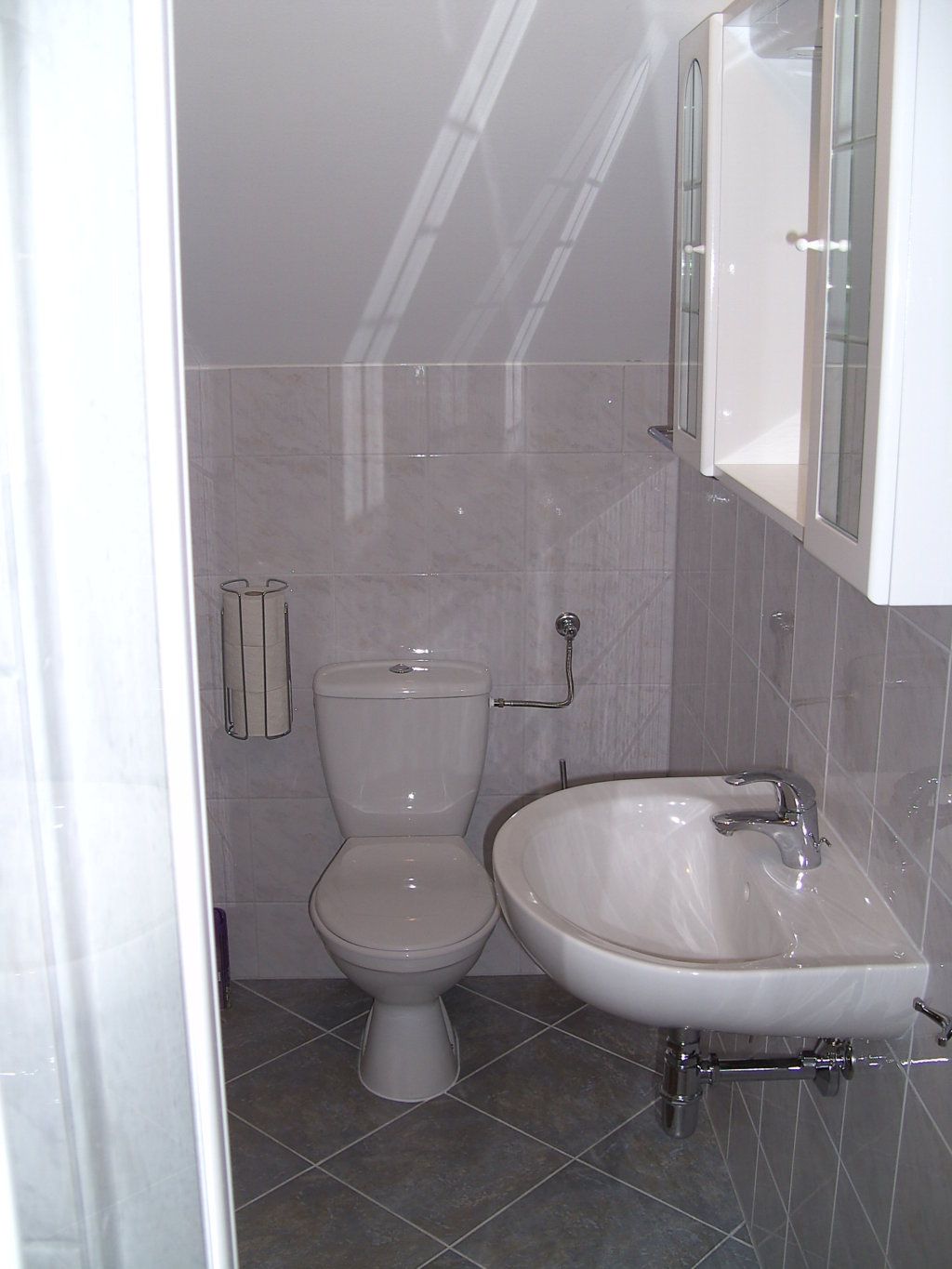 Kis fürdőszoba WC-vel és mosdókagylóval.