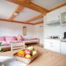 Gem&uuml;tliche Ferienwohnung mit Holzm&ouml;beln, K&uuml;che und Schlafbereich.