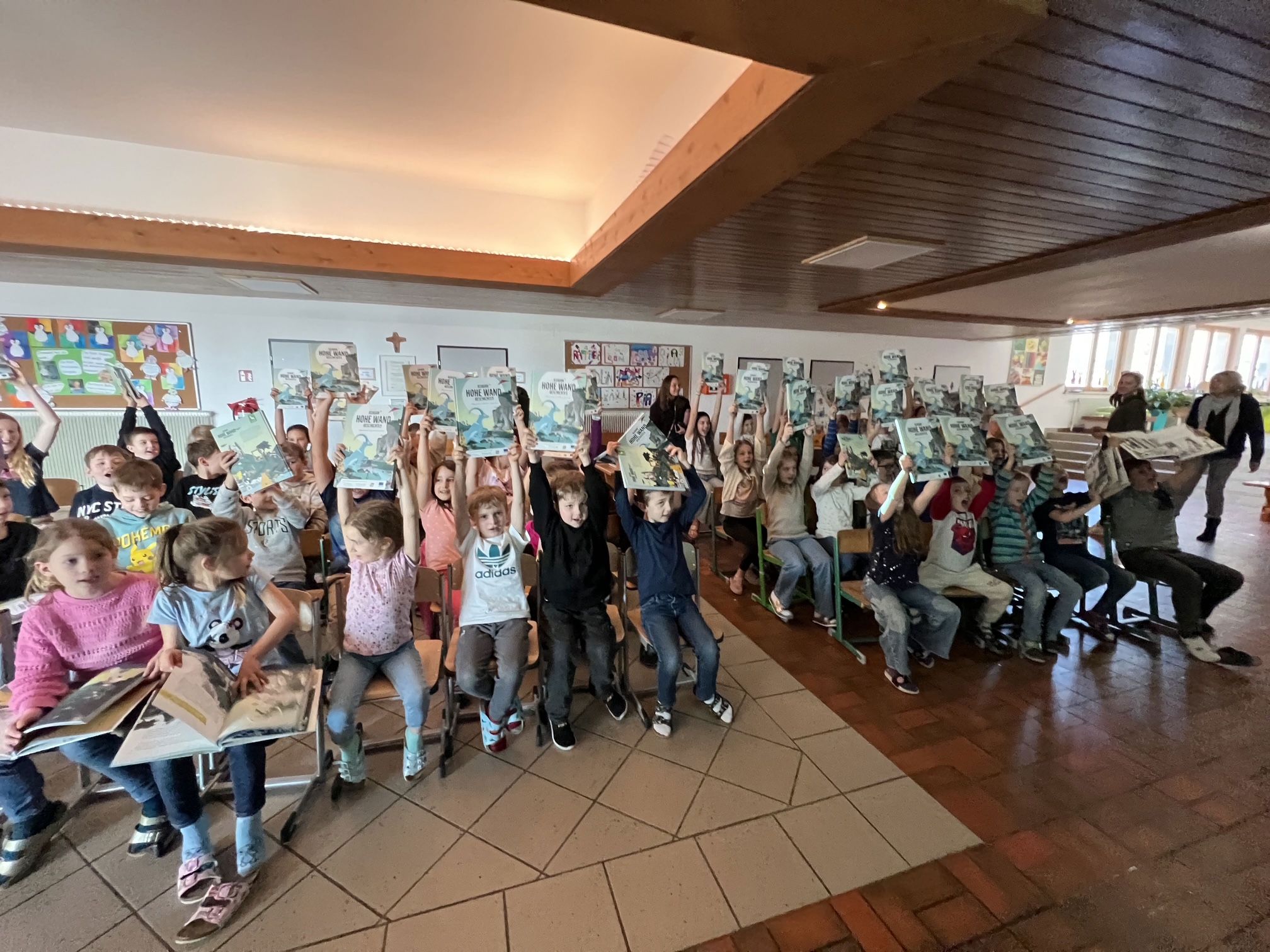 Alle Kinder der Naturpark Schule Hohe Wand halten ihr Buch in die Höhe