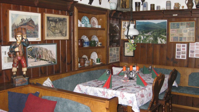 Rustic dining room with wooden furniture, wall decorations and table setting.