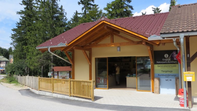 Eingang eines Naturpark-Zentrums mit Holzveranda und Informationsschild.