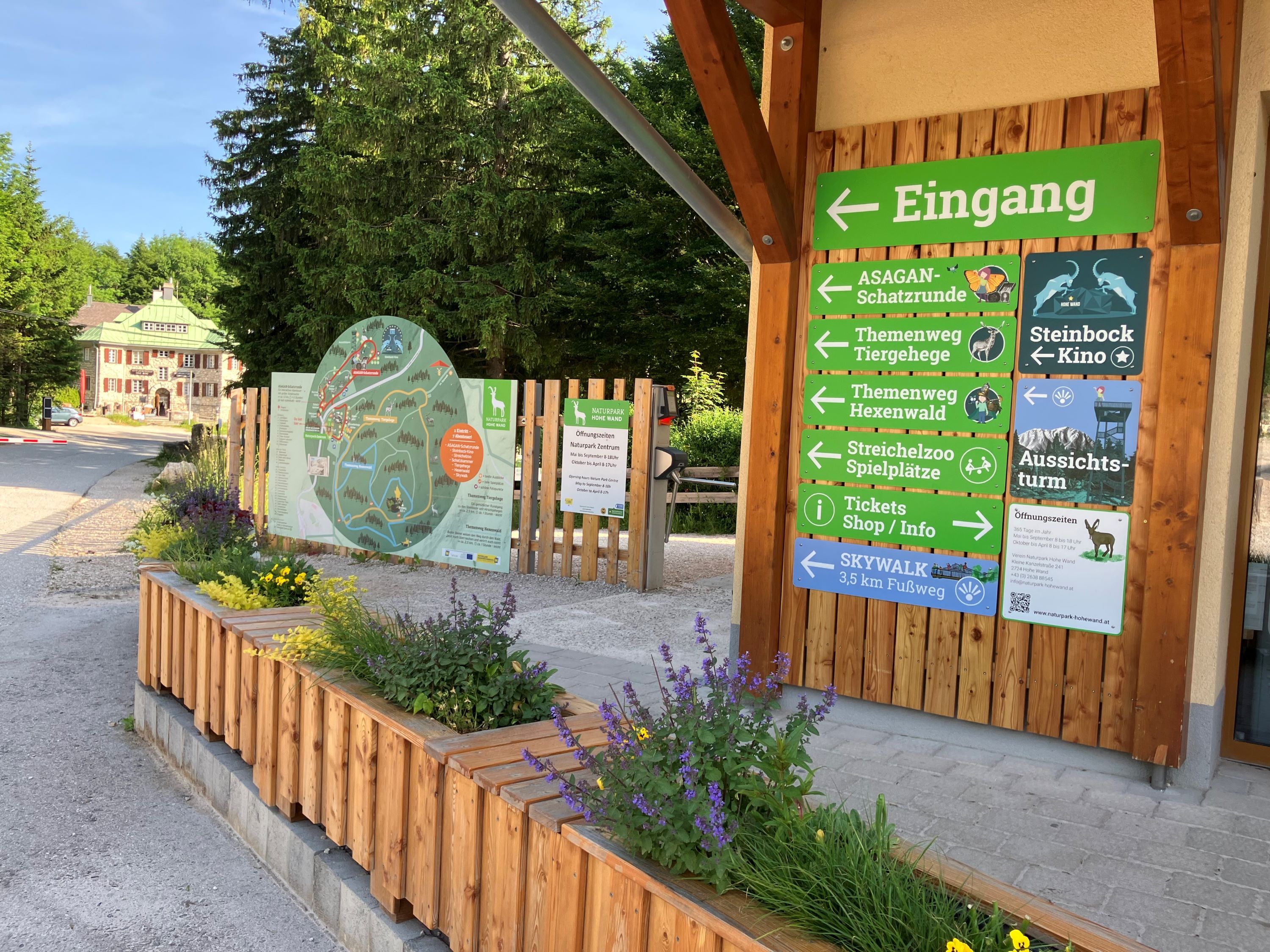 Wegweiser neben dem Eingang zum Naturpark Zentrum, im Hintergrund das Naturpark Stüberl