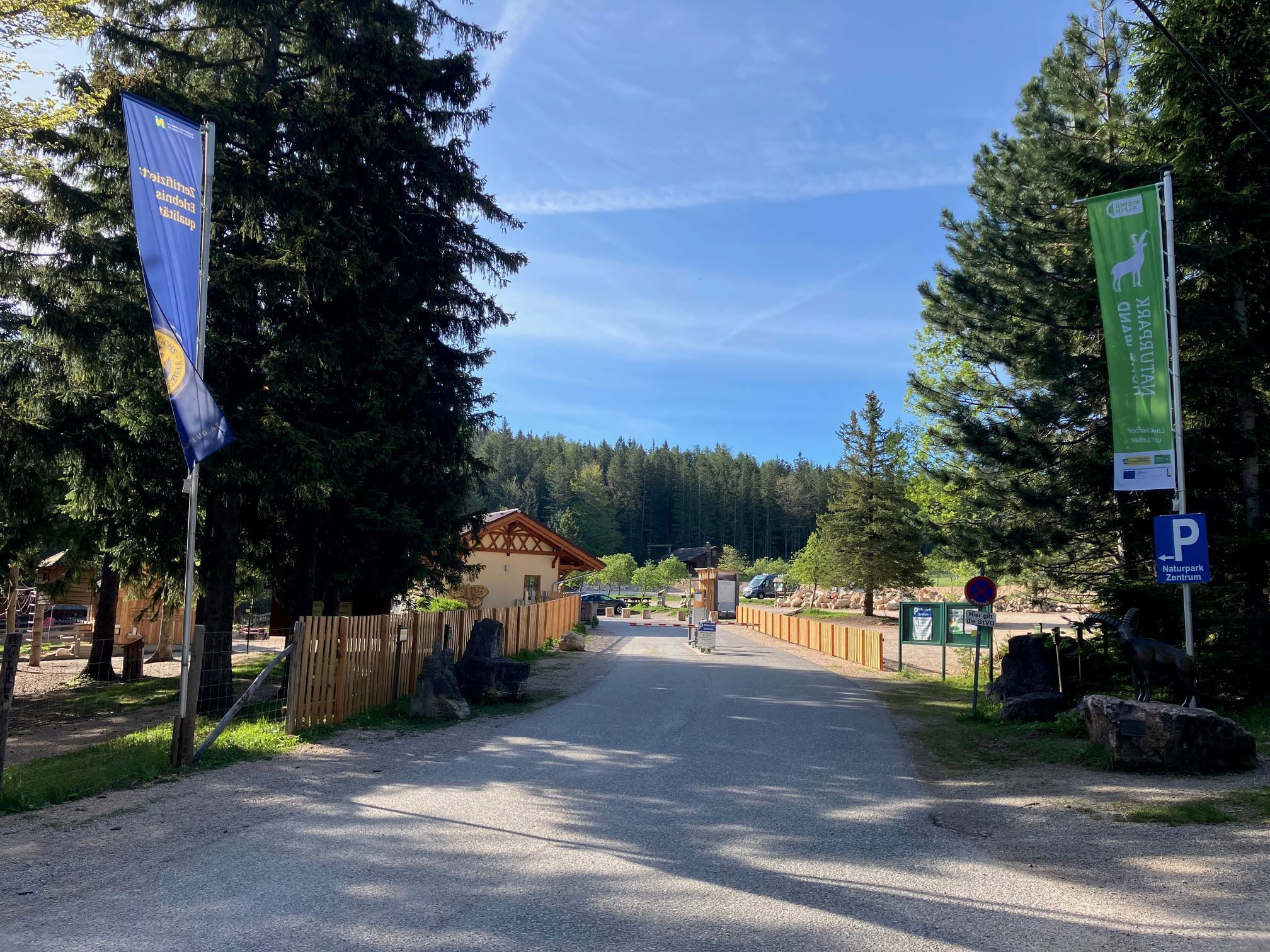 Entrance to the nature park center with flags and trees.