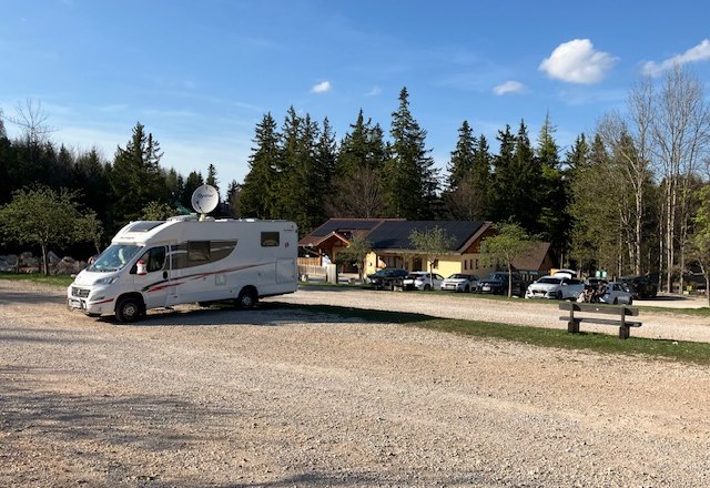 Wohnmobil auf einem Parkplatz vor einem Gebäude im Naturpark Hohe Wand.