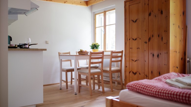 Gem&uuml;tliche Ferienwohnung mit Holzm&ouml;beln, Esstisch und Bett.